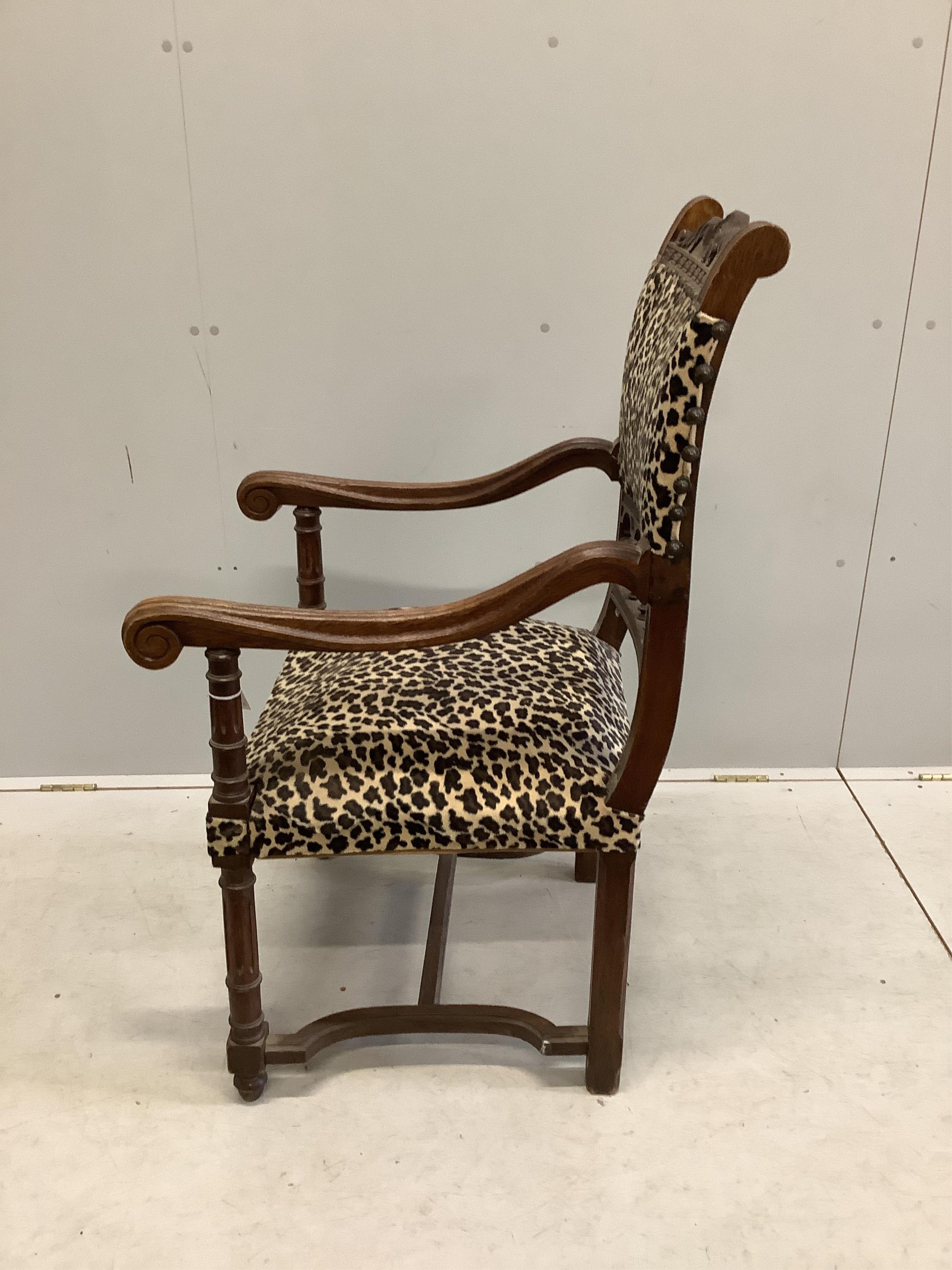 An oak elbow chair with leopard print fabric, and one other oak elbow chair, larger width 59cm, depth 65cm, height 112cm. Condition - fair